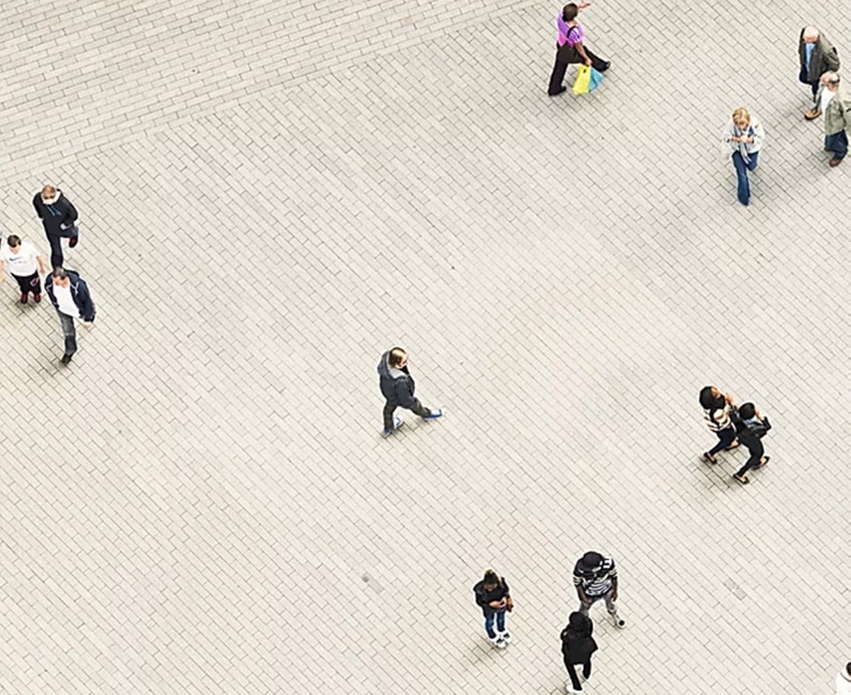 Photographie aérienne de différents individus flânant sur une esplanade.